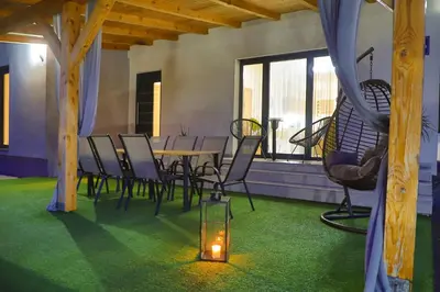 a dining room with a table and chairs and a candle at Villa Bubinka in Bihać