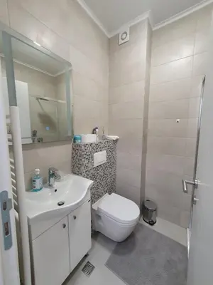 a white bathroom with a toilet and a sink at Apartman Milekic in Banja Luka