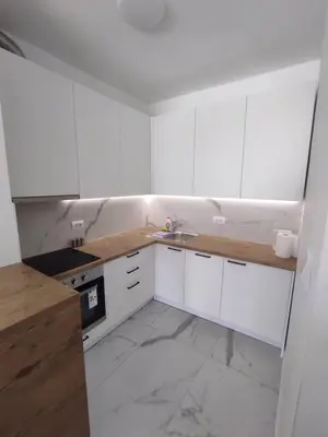 a white kitchen with white cabinets and a sink at Apartman Milekic in Banja Luka