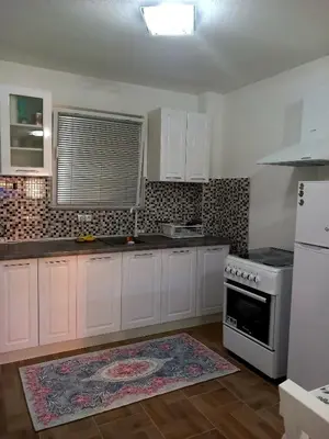 a kitchen with white cabinets and a stove at Apartman Leon in Bihać
