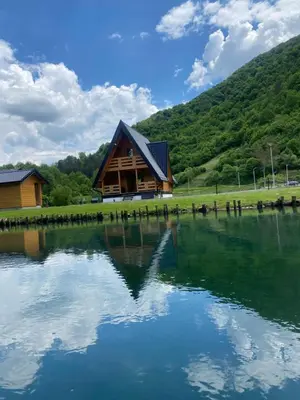 a log cabin sitting on top of a lake at Bungalow Jajce 1 in Jezero