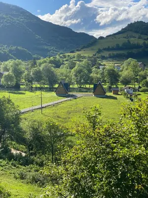 a group of tents in a field with mountains in the background at Bungalow Jajce 2 in Jezero