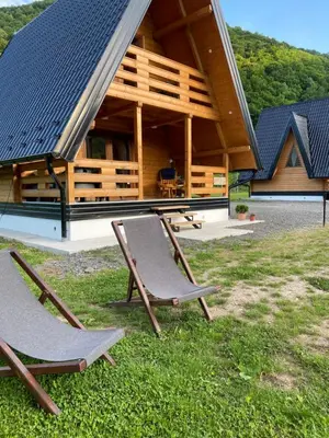 two chairs sitting in the grass in front of a building at Bungalow Jajce 2 in Jezero