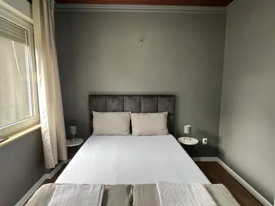 a bedroom with a large bed with two tables at Lux apartments Crystal-center in Bihać
