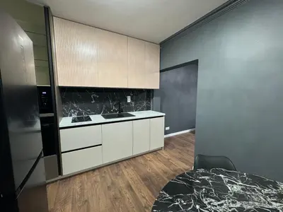 a kitchen with white cabinets and a black counter top at Lux apartments Crystal-center in Bihać