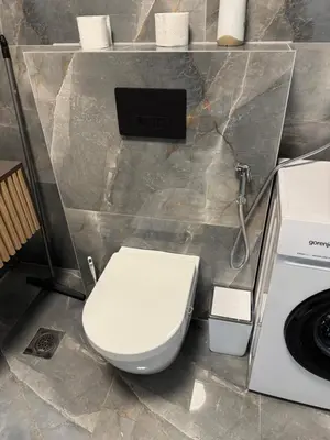 a bathroom with a toilet and a washing machine at Lux apartments Crystal-center in Bihać