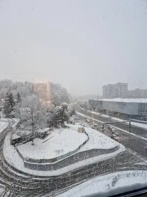 a snow covered street with a city in the background at Smart Loft Apartment - connection of city center and luxury in Tuzla