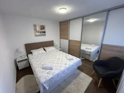 a small bedroom with a bed and a chair at New apartment - Moon in Banja Luka