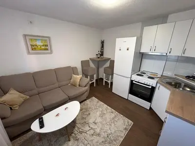 a small living room with a couch and a kitchen at New apartment - Moon in Banja Luka