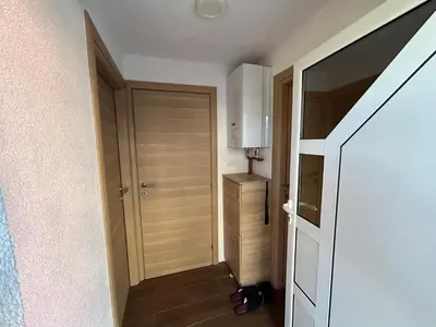 a hallway with a door to a room with a table at New apartment - Moon in Banja Luka