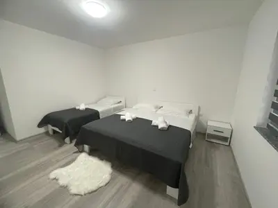 a bedroom with two beds and a rug at Apartmani Franciska in Jajce