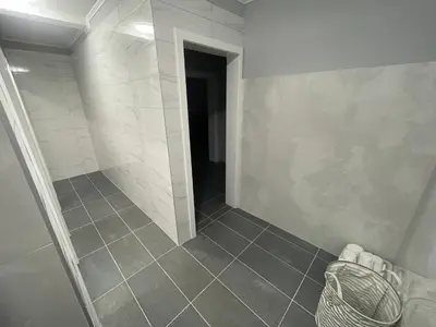 a bathroom with a walk in shower and a tile floor at Apartmani Franciska in Jajce
