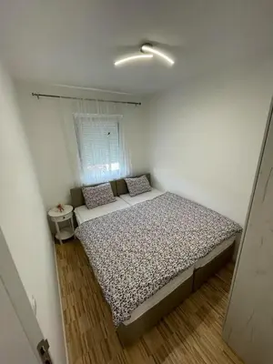 a small bedroom with a bed and a window at Apartman Afrodita in Bosanska Gradiška