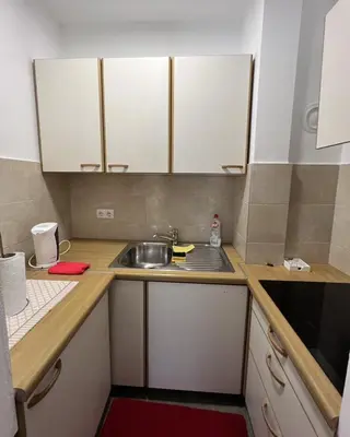 a small kitchen with white cabinets and a sink at Apartman Afrodita in Bosanska Gradiška