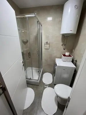 a small bathroom with a shower and two toilets at Apartman Afrodita in Bosanska Gradiška