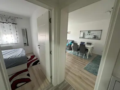 a bedroom with a bed and a dining room with a table at Stan na dan Tamaris in Modriča
