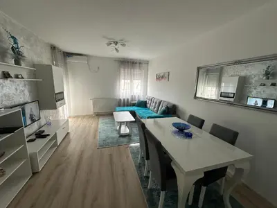 a living room with a table and a blue couch at Stan na dan Tamaris in Modriča
