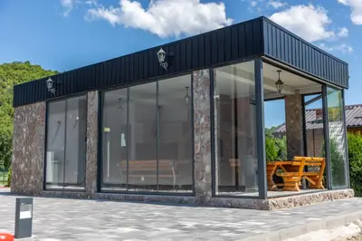 a glass house with a black roof at Villa UNA LUX in Bihać