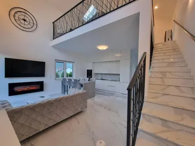 a living room with a staircase and a fireplace at Villa UNA LUX in Bihać