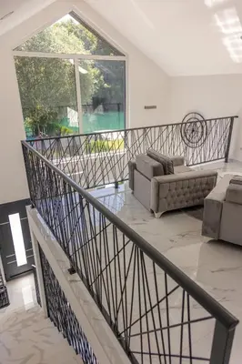 a living room with a staircase with couches and a window at Villa UNA LUX in Bihać