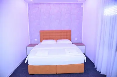 a bedroom with a large bed with white sheets at Vb apartmani in Prijedor