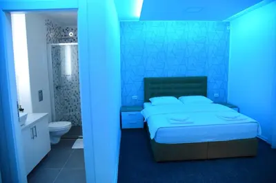 a blue bedroom with a bed and a bathroom at Vb apartmani in Prijedor