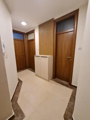 an empty hallway with wooden doors and a tile floor at AGERA Apartments in Banja Luka