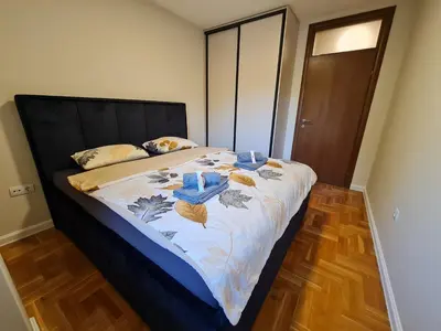 a bedroom with a large bed with blue candles on it at AGERA Apartments in Banja Luka