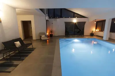 a large swimming pool with blue lights in a building at R&J's Home in Bihać