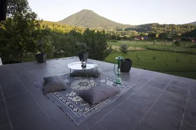 a table with two pillows on a patio with a view at R&J's Home in Bihać
