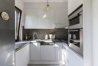 a white kitchen with white cabinets and a sink at R&J's Home in Bihać