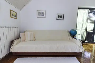 a bed in a room with white walls at R&J's Home in Bihać