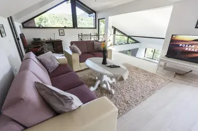 a living room with a purple couch and a tv at R&J's Home in Bihać