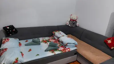 a bed with pillows and a teddy bear on top of it at Ema Apartman in Livno