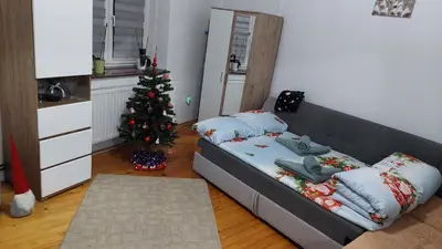 a room with a bed and a christmas tree at Ema Apartman in Livno