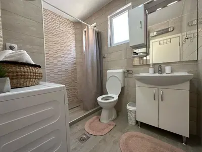 a bathroom with a toilet and a sink and a mirror at Apartment DUNJA Laktasi in Laktaši