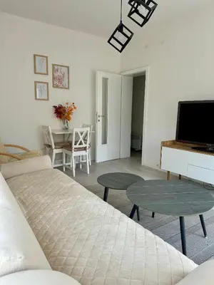 a living room with a bed and a tv and a table at Apartment DUNJA Laktasi in Laktaši