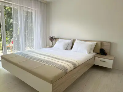 a large bed in a room with a large window at Apartment DUNJA Laktasi in Laktaši