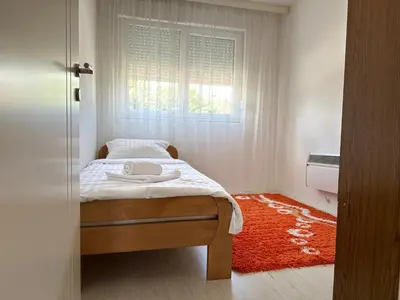 a small bedroom with a bed and a window at Apartment DUNJA Laktasi in Laktaši