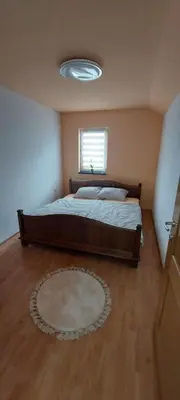 a bedroom with a large bed and a window at Apartman Citadel in Gradačac