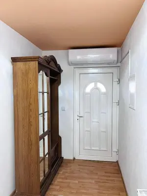 a hallway with a white door and a wooden cabinet at Apartman Citadel in Gradačac