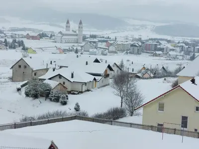 a town covered in snow with a city in the background at Apartment Una in Kupres