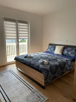a bedroom with a bed with a blue comforter at Apartment Una in Kupres