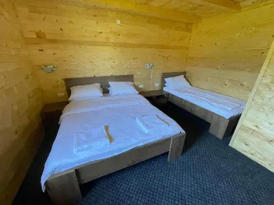 a room with two beds in a wooden cabin at Etno zona Oaza mira in Donji Vakuf