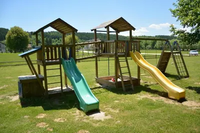 a group of playground equipment with slides in a field at Etno zona Oaza mira in Donji Vakuf
