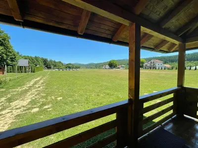 a view of a field from the porch of a barn at Etno zona Oaza mira in Donji Vakuf
