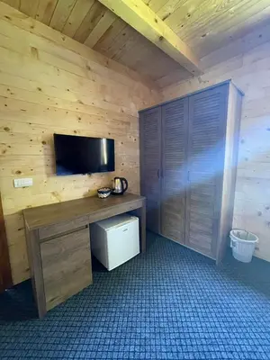 a room with a desk with a tv on a wooden wall at Etno zona Oaza mira in Donji Vakuf