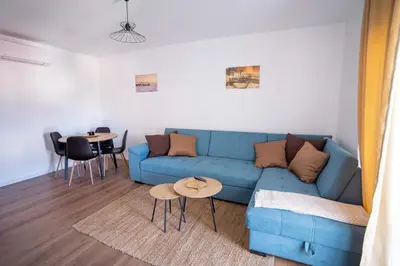 a living room with a blue couch and two tables at Apartman Niko in Livno