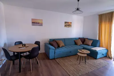 a living room with a blue couch and a table at Apartman Niko in Livno