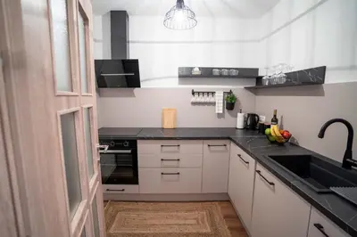 a kitchen with white cabinets and a black counter top at Apartman Niko in Livno